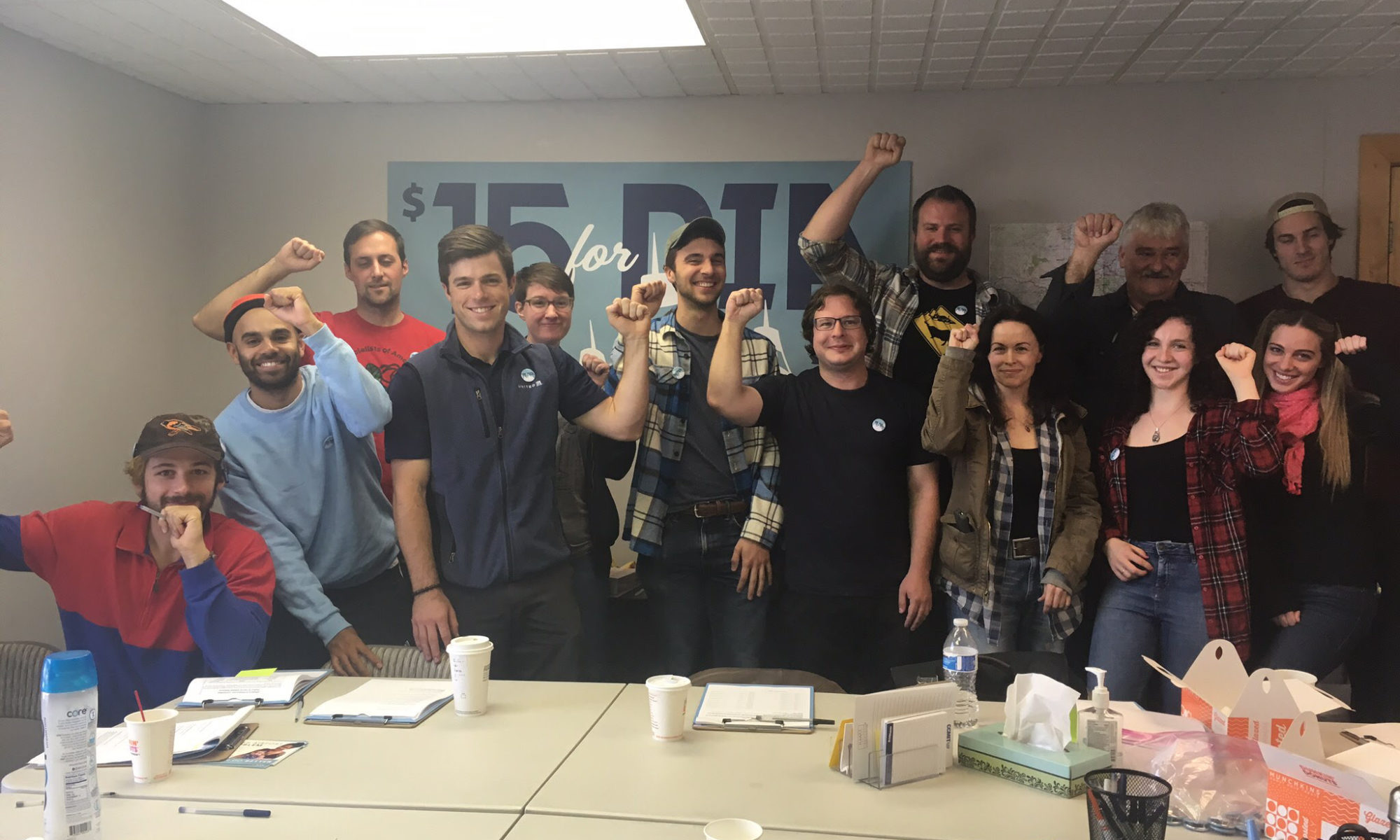 Denver DSA members raising fists during $15 for DIA campaign